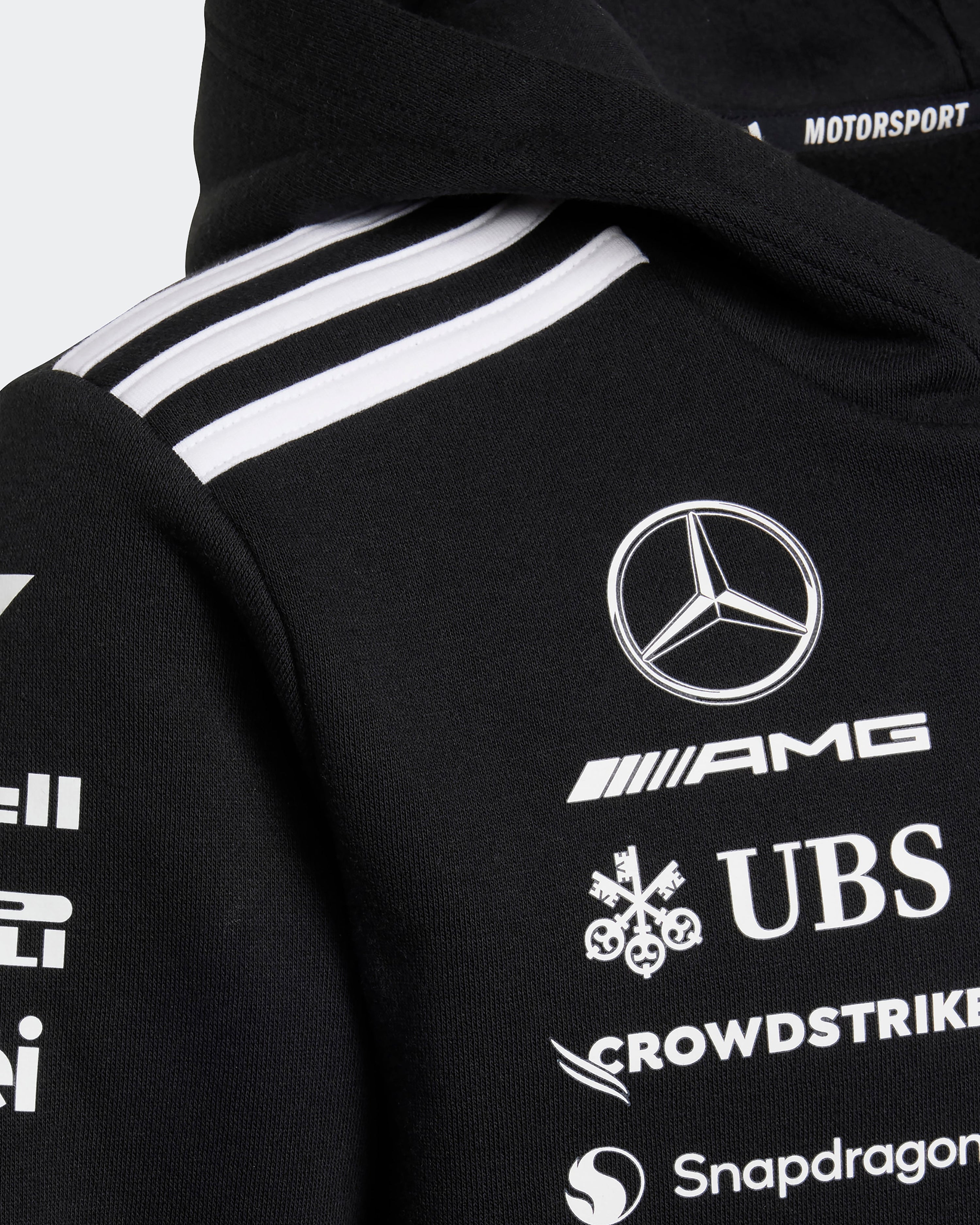 Kids 2025 Team Hoody Black — close-up design detail showing Mercedes-AMG PETRONAS F1 styling and product details | Dash Racegear