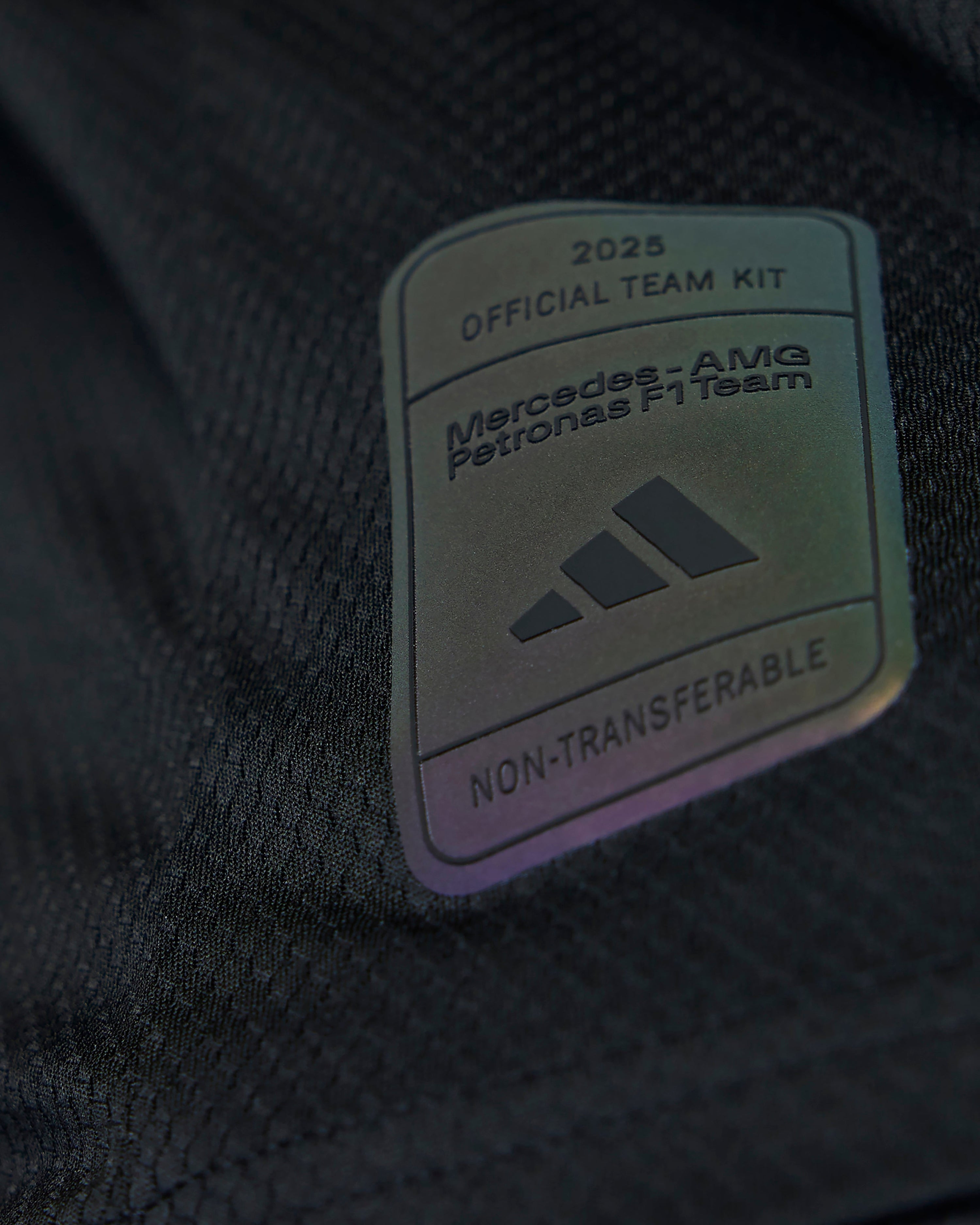 Mens 2025 Authentic Driver Tee Black — close-up design detail showing Mercedes-AMG PETRONAS F1 styling and product details | Dash Racegear
