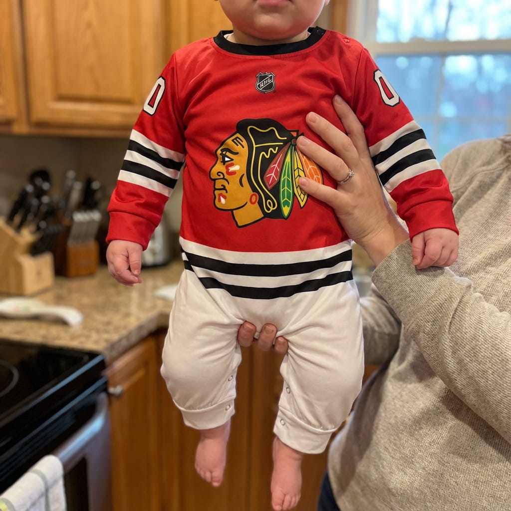 Chicago Blackhawks - Hockey Baby Onesie Jumpsuit - Baby Wearing Chickago Blackhawks Baby Onsie Jumpsuit Held By Their Mother | Dash Racegear